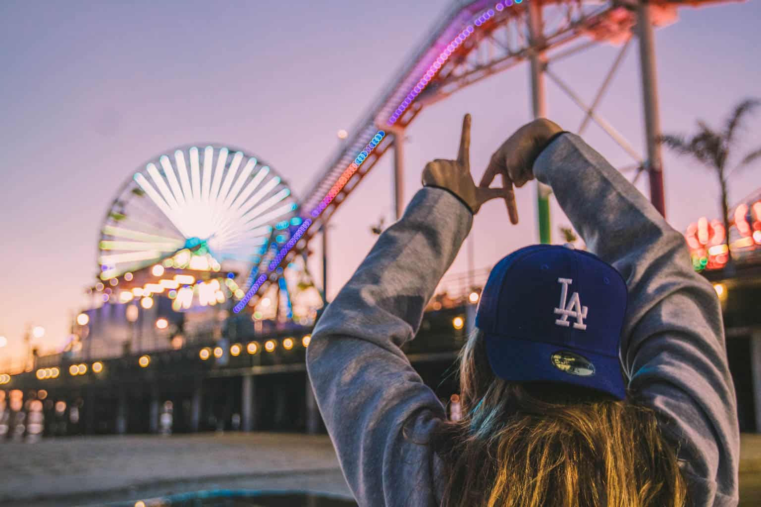 Person in front of a roller coaster.