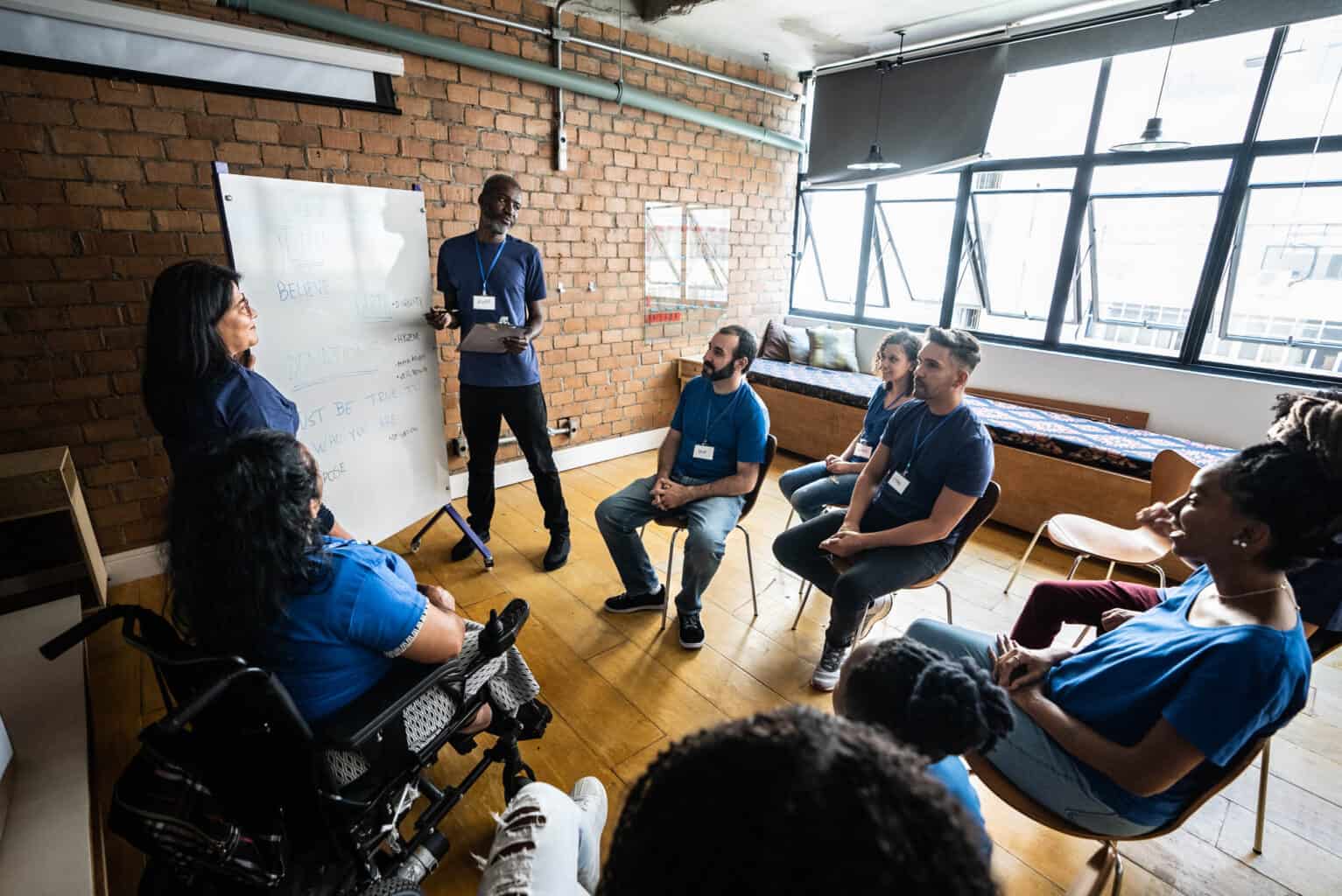 Group of people in a room listening to someone speak.